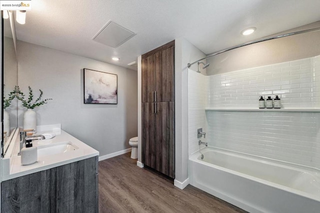 full bathroom featuring toilet, tiled shower / bath, wood-type flooring, and vanity