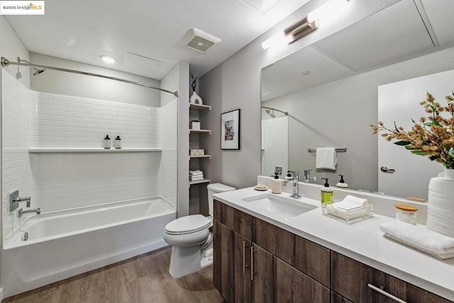 full bathroom with toilet, vanity, wood-type flooring, and tiled shower / bath