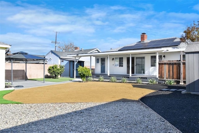 view of front of home with a gazebo, solar panels, and a porch