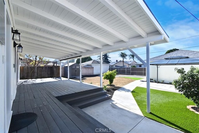 wooden deck with a storage unit and a yard