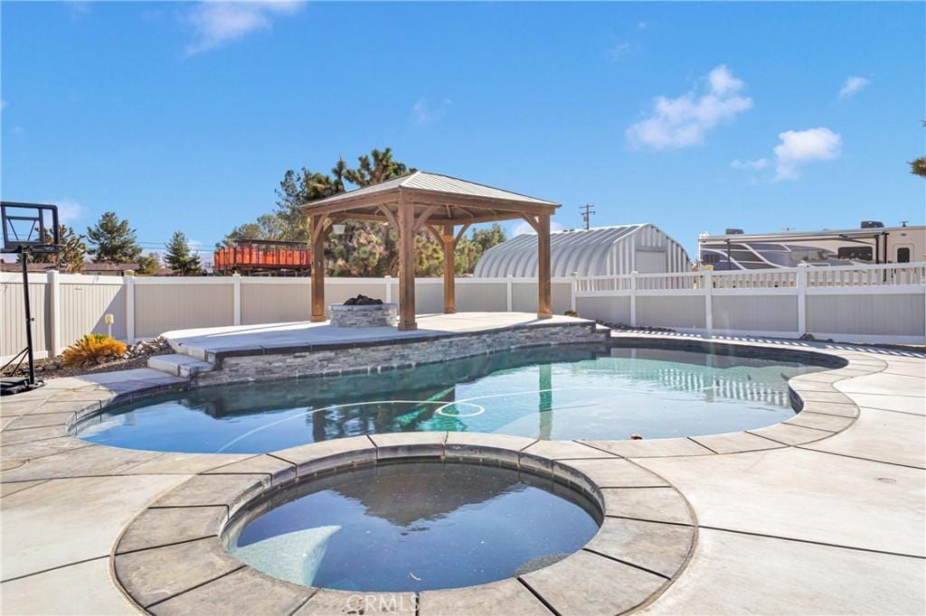 view of swimming pool featuring an in ground hot tub and a gazebo