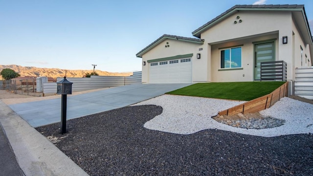 view of front facade with a front yard, a garage, and a mountain view