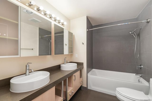 full bathroom featuring toilet, vanity, tiled shower / bath combo, and tile patterned floors