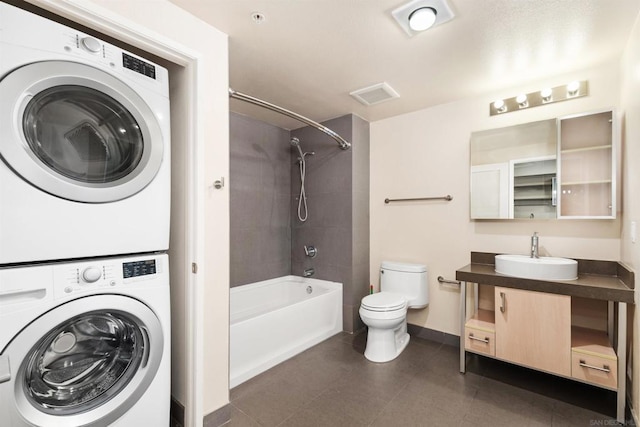 full bathroom featuring shower / bathing tub combination, stacked washer and clothes dryer, toilet, and vanity