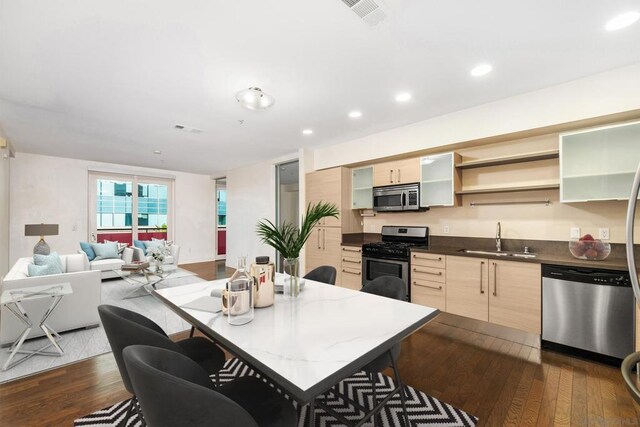 kitchen with light brown cabinetry, sink, dark hardwood / wood-style floors, and stainless steel appliances