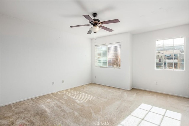 carpeted spare room featuring ceiling fan