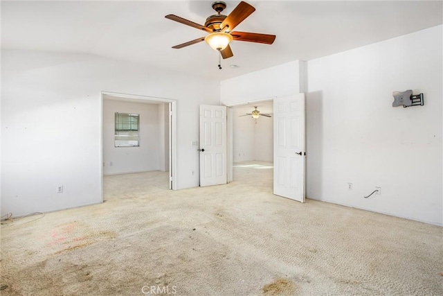 empty room with ceiling fan and light carpet