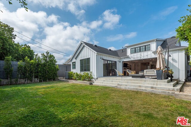 back of property with a lawn, outdoor lounge area, and a patio