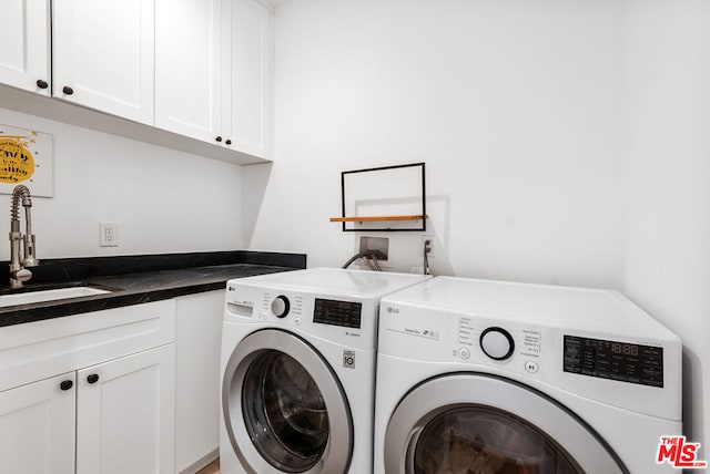 washroom featuring cabinets, separate washer and dryer, and sink