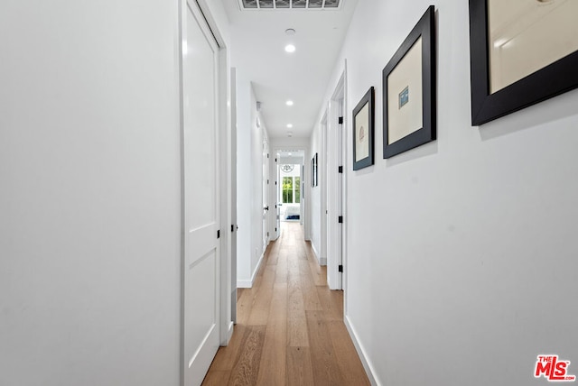 corridor with light hardwood / wood-style floors