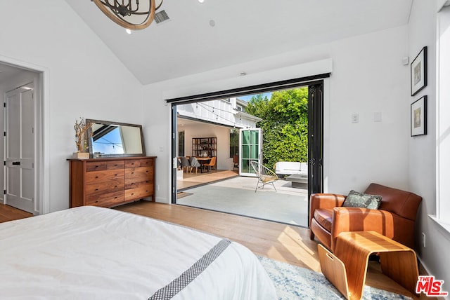 bedroom featuring high vaulted ceiling and light hardwood / wood-style flooring