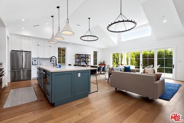 kitchen featuring white cabinetry, an inviting chandelier, high end fridge, and hanging light fixtures