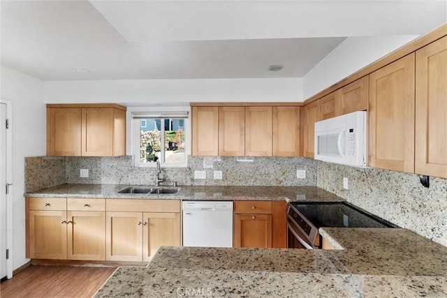 kitchen with backsplash, light stone countertops, sink, and white appliances