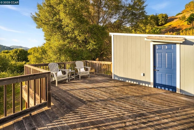 wooden terrace featuring a storage unit