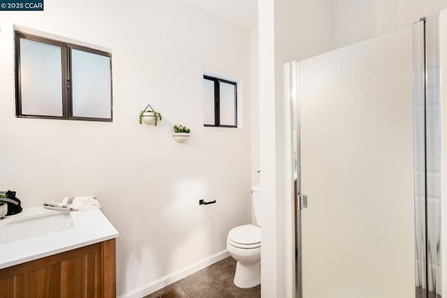 bathroom featuring toilet, a shower with door, tile patterned floors, and vanity