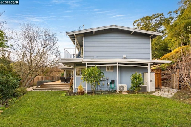 back of property with a lawn, ac unit, cooling unit, and a balcony