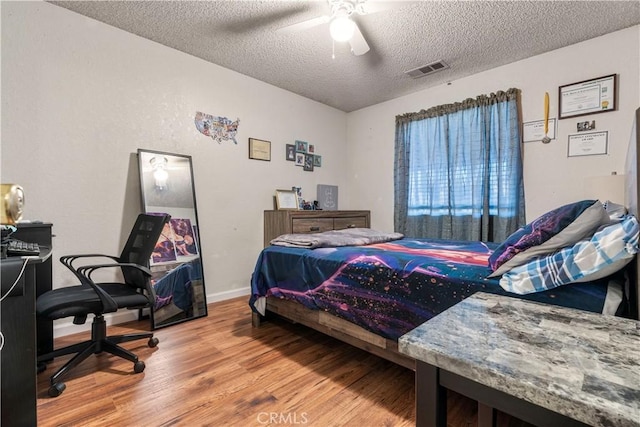 bedroom featuring a textured ceiling, ceiling fan, and hardwood / wood-style floors