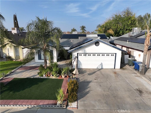 view of front of house featuring a front lawn, solar panels, and a garage