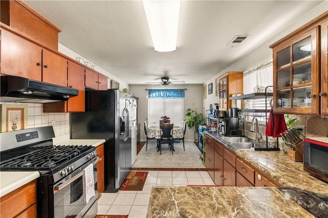 kitchen featuring ceiling fan, tasteful backsplash, sink, light tile patterned flooring, and appliances with stainless steel finishes