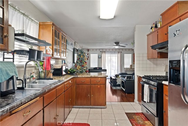 kitchen featuring appliances with stainless steel finishes, sink, backsplash, ceiling fan, and light tile patterned floors