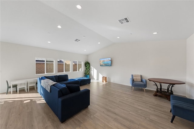 living room featuring hardwood / wood-style flooring and vaulted ceiling