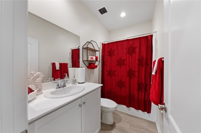 full bathroom featuring toilet, vanity, shower / bath combo with shower curtain, and hardwood / wood-style floors