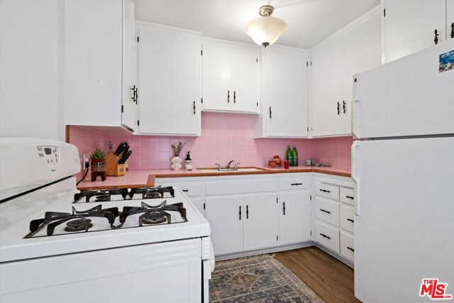 kitchen with decorative backsplash, white appliances, dark hardwood / wood-style flooring, white cabinets, and sink