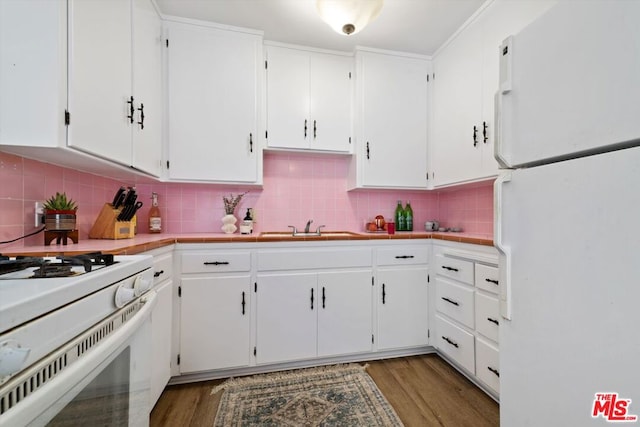 kitchen with decorative backsplash, white appliances, and white cabinetry