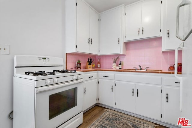 kitchen featuring white cabinetry, backsplash, white appliances, and wood-type flooring