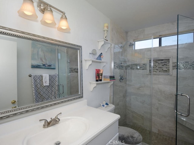 bathroom featuring a shower with door and vanity