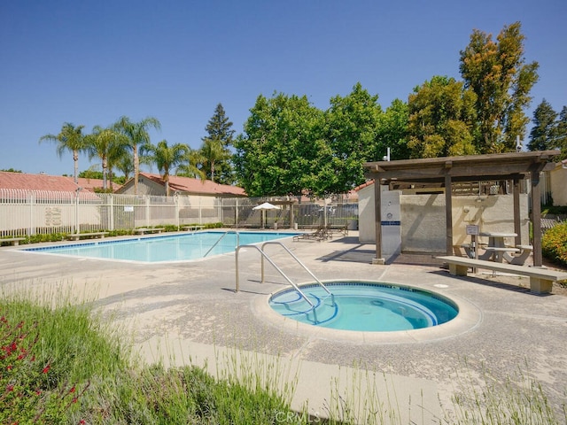 view of swimming pool with a patio area and a hot tub