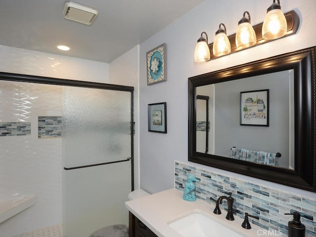 bathroom with a shower with shower door, decorative backsplash, and vanity