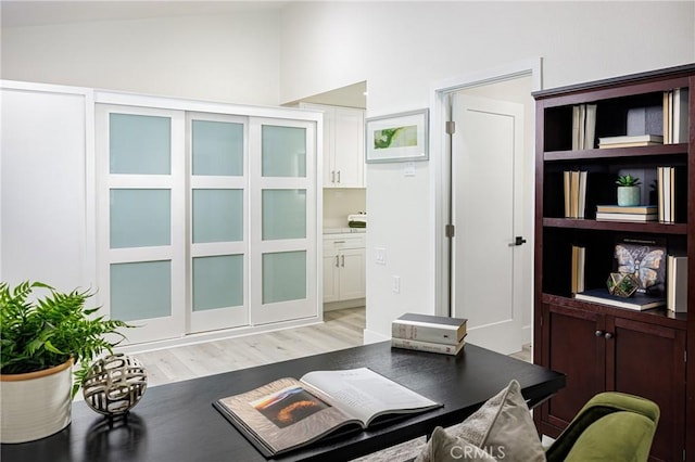 office space featuring lofted ceiling and light hardwood / wood-style floors