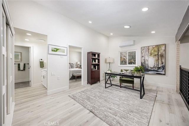 office area with an AC wall unit, light hardwood / wood-style flooring, and lofted ceiling