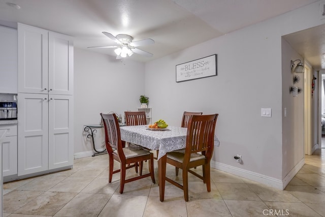 dining space with ceiling fan and light tile patterned floors