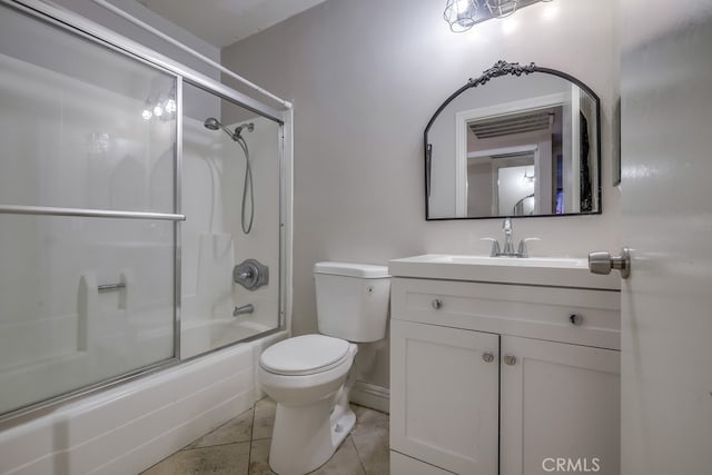 full bathroom with tile patterned flooring, vanity, shower / bath combination with glass door, and toilet