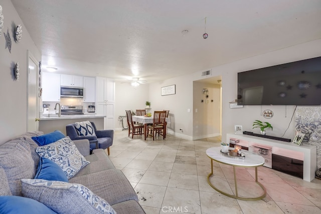 tiled living room featuring sink and ceiling fan