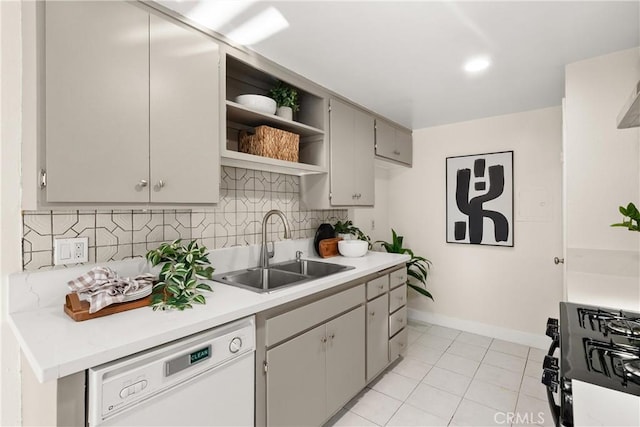 kitchen with light tile patterned floors, gray cabinetry, dishwasher, black range with gas cooktop, and sink