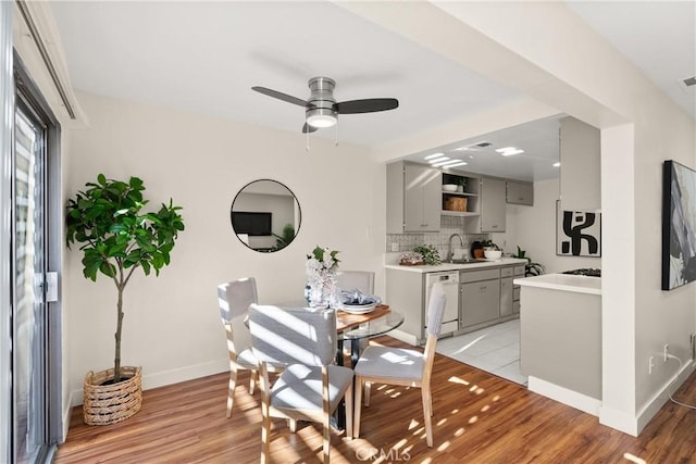 dining room featuring ceiling fan, sink, and light hardwood / wood-style floors