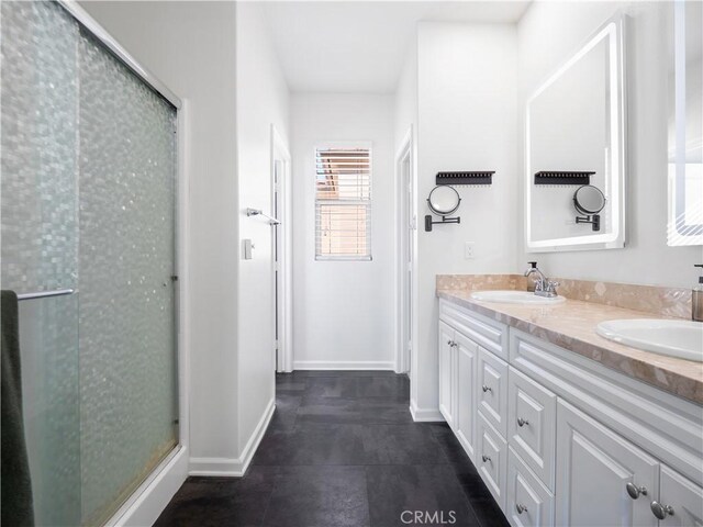 bathroom with vanity and a shower with door