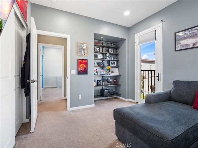 living area with light colored carpet and built in shelves