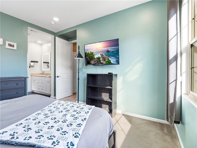 bedroom featuring light colored carpet and ensuite bath