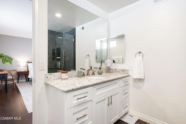 bathroom with walk in shower, hardwood / wood-style floors, and vanity