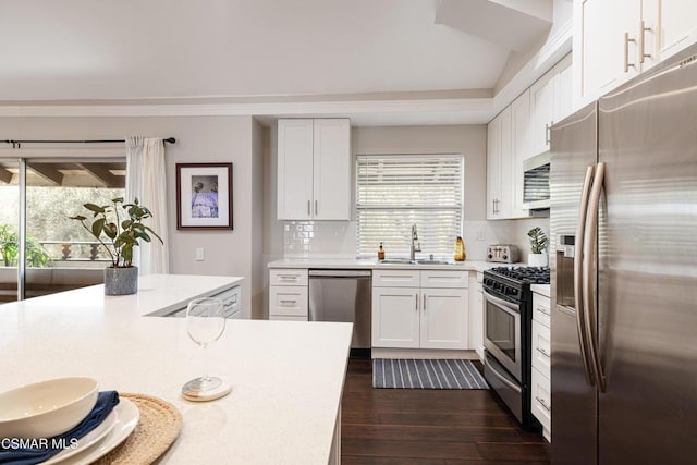 kitchen featuring white cabinets, backsplash, appliances with stainless steel finishes, and sink