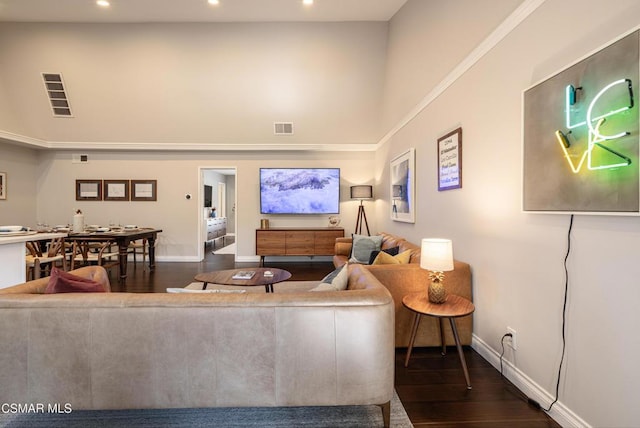 living room featuring dark hardwood / wood-style flooring and a towering ceiling