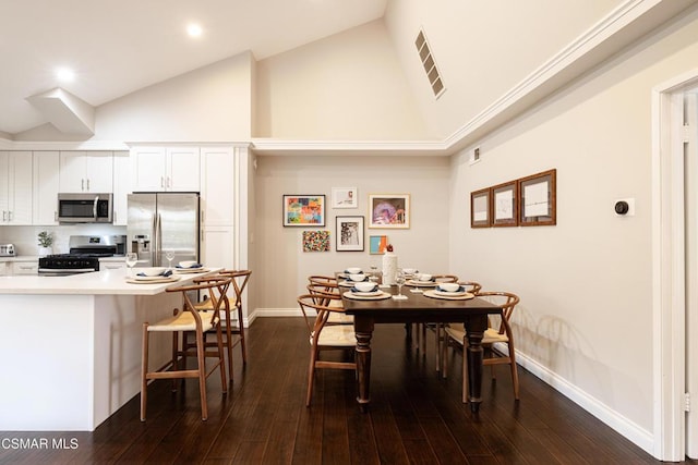 dining room featuring dark wood-type flooring and high vaulted ceiling