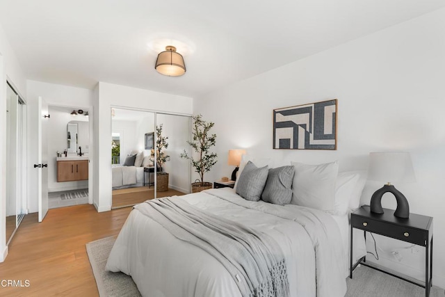 bedroom featuring ensuite bathroom and hardwood / wood-style floors