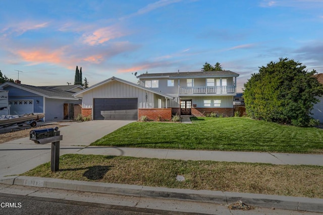 view of front property with a lawn, a balcony, and a garage