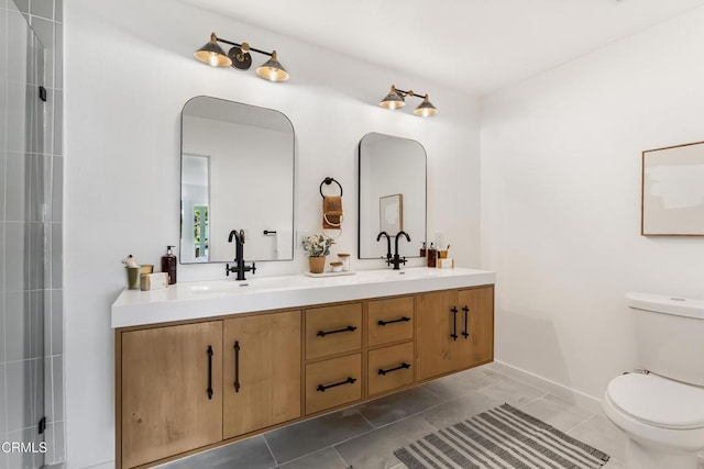 bathroom with toilet, vanity, and tile patterned floors