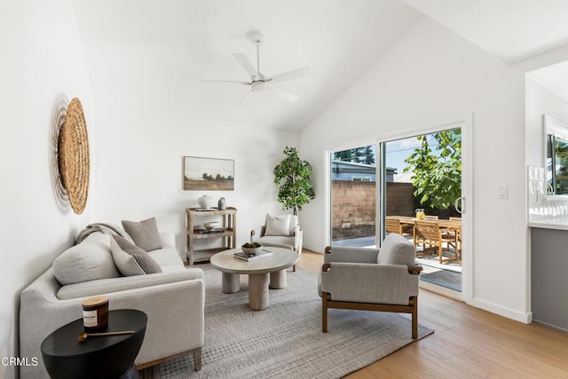 living room with ceiling fan, high vaulted ceiling, and light hardwood / wood-style flooring